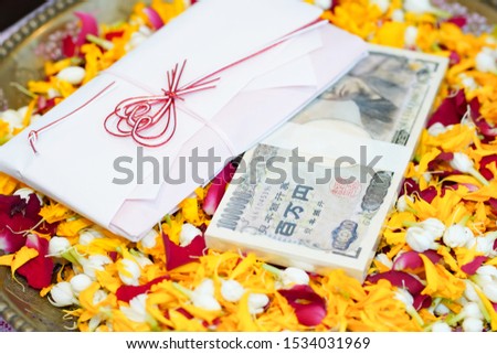 Gold necklaces, gold rings, bank notes, and valuables placed on flowers at Thai wedding ceremonies
To be a valuable thing in weddings