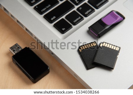 Memory Cards, Flash Drive, Card Reader, Laptop computer on wooden background