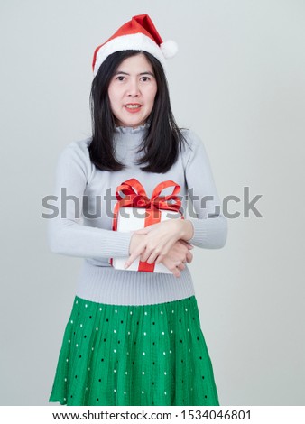 Christmas Concept. Young beautiful woman in santa hat with gift box in hand on white background