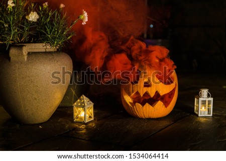 Spooky halloween pumpkin with red smoke coming out of eyes