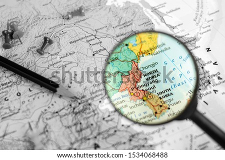 note device and magnifier selective at north korea and south korea map. - economic and travel concept.