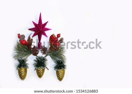 Group of Christmas decorations on white background with copy space for your text. Purple star, artificial fir tree branches and Christmas balls in form of golden cones on the left side of photo.