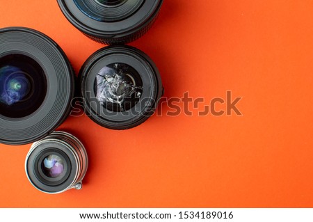 broken modern photo lens on a colored background, photographic equipment repair concept, copy space