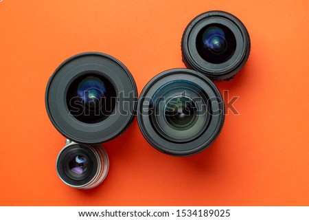 Progress of different photo lenses on a colored background, a set of old and modern photo devices for the camera, copy space