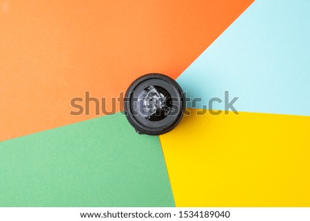 one broken modern photo lens on a colored background, photographic equipment repair concept, copy space