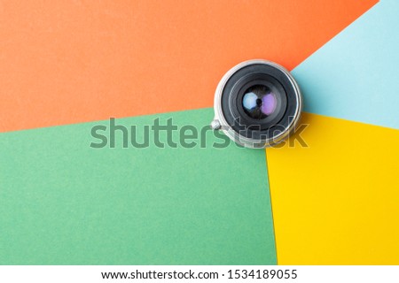 one small old photo lens on a colored background, digital color rendering concept, copy space