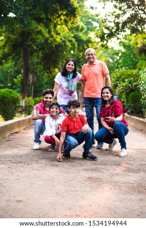 Portrait of Indian Family of six, enjoying Picnic or morning walk - Multi generation of asian family posing at a walkway at park, outdoor. selective focus