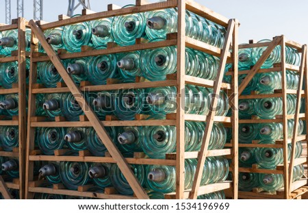 Glass insulators in a wooden pallet for installation of a high-voltage line at a power plant