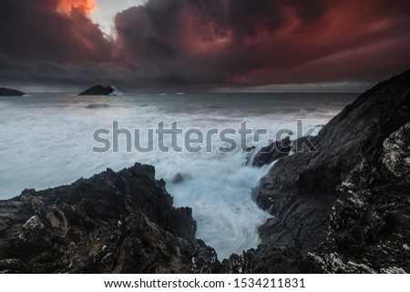 A stormy day at the mountainous shore of the ocean under the stormy sky in Holywell Bay, Cornwall, UK