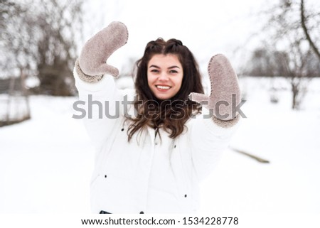 
brunette in white jacket and warm gloves having fun