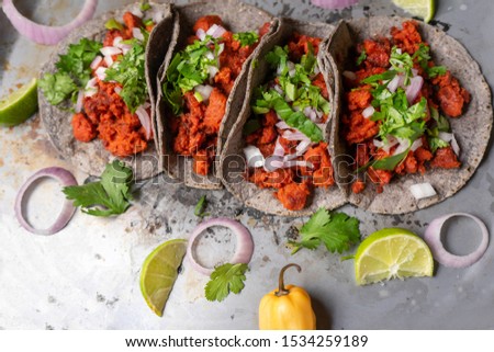 Traditional mexican chorizo tacos with blue corn tortillas on rustic background