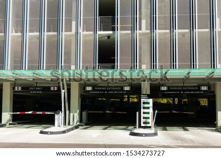 Multi level parking garage entrance and exit. Spaces available outdoor parking sign with LED counter indicating the number of open or empty parking spaces at garage levels. 