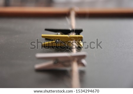 Small pegs hanging on rope, colorful, close up, chalkboard background