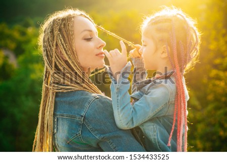 Mother and daughter with braiding hair. Nice child girl with plaits. Hair in trendy weave plait