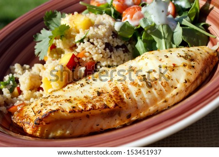 Baked tilapia served with arugula and quinoa salad