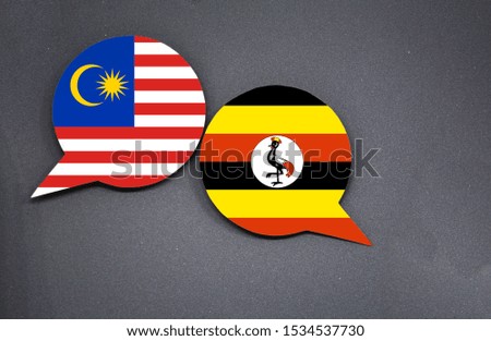 Malaysia and Uganda flags with two speech bubbles on dark gray background
