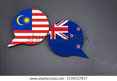 Malaysia and New Zealand flags with two speech bubbles on dark gray background