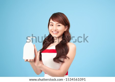 Beautiful Asian asian woman holding and presenting white cosmetic tube, Beauty skin care concept