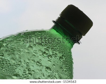 Close-up of water bottle with sparkling drops and a green impression