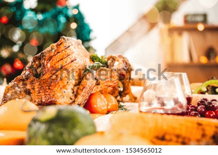 Roasted  chicken or turkey with sauce and grilled autumn vegetables: corn,pumpkin  on wooden table, top view, frame. Christmas or Thanksgiving Day food concept.