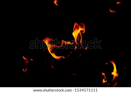 Blurred fire flame glowing burning on black dark background