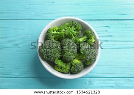 Bowl of fresh green broccoli on blue wooden table, top view Royalty-Free Stock Photo #1534621328