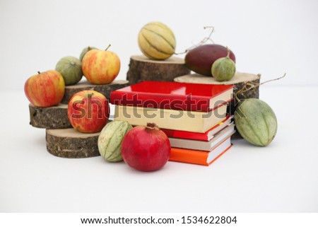 Autumn fruits and books on white background