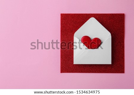 Composition with white envelope and red wooden heart on pink background, top view. Space for text
