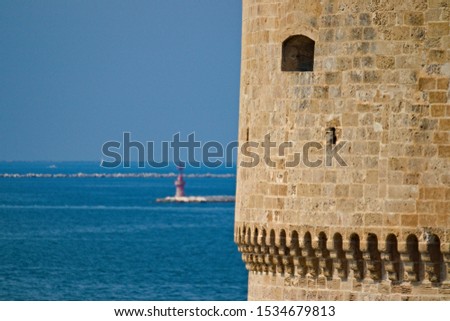 Detail of a tower of the Aragonese Castle in Taranto, Puglia, Italy, with sea in background