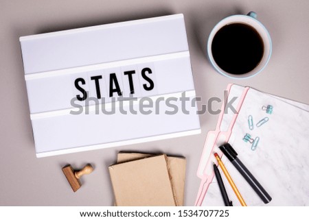 Stats, business, profits, annual report and feedback concept.  White lightbox on a grey office desk