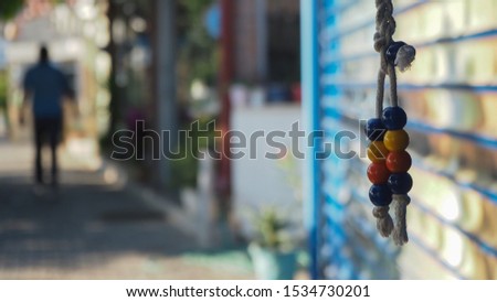 Colorful down beads hanging on rope and silhouettes of people crossing the street