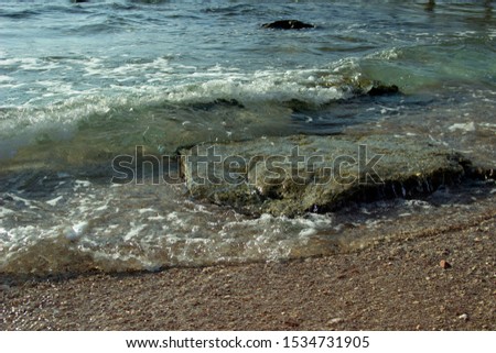 Summer background of hot sand with sea or ocean wave bubbles with copy space for card or advertisement at dawn or sunset 