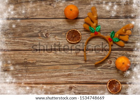 Wooden background with decoration Christmas deer antlers and mandarines on the table. Winter holiday frame. Flat lay top view. copy space