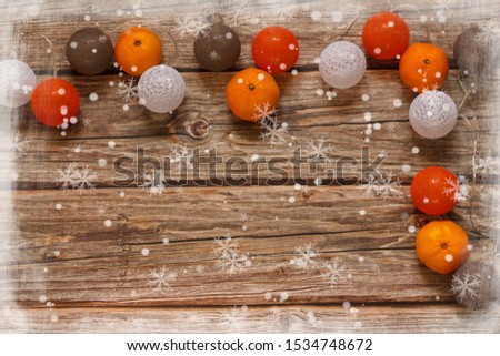 Wooden background with Christmas decoration balls and mandarines on the table. Winter holiday frame. Flat lay top view. copy space