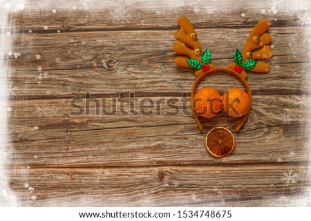 Wooden background with decoration Christmas deer and mandarines on the table. Winter holiday frame. Flat lay top view. copy space