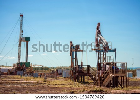 Oil pump jack rocking with pipeline in the background. Rocking machines for power generation. Extraction of oil