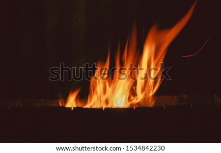 a bonfire burns in metal box
