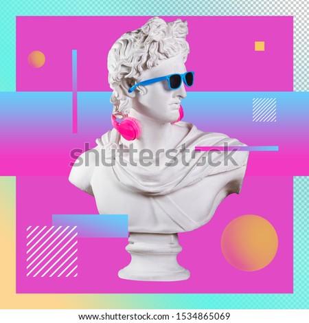 Statue. Earphone on a abstract background. Gypsum statue of Apollo head. Creative. Plaster statue of Apollo's head in blue sunglasses. Minimal concept art.