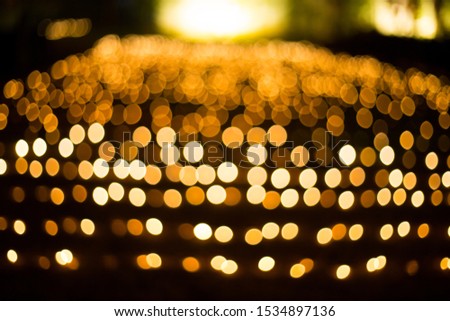 abstract blurred of golden yellow glittering shine fairy bulbs lights bokeh background: blur of Christmas wallpaper decorations concept.xmas holiday festival backdrop:sparkle lit celebrations display.