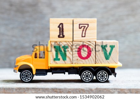 Truck hold letter block in word 17nov on wood background (Concept for date 17 month November)