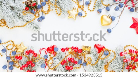 Christmas composition with holly berries, snowflake and green fir branch on white background. Xmas flat lay top view on stucco texture with copy space