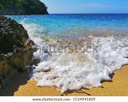 A picture of waves crashing at against rocks and spraying over the sand. Great as a wallpaper or similar background. 