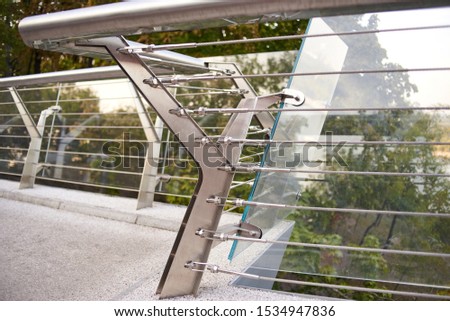 A modern bridge over a river fenced by a glass fence.