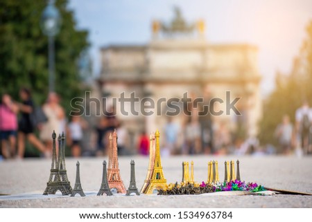 Miniature souvenirs of the Eiffiel Tower being sold in the street