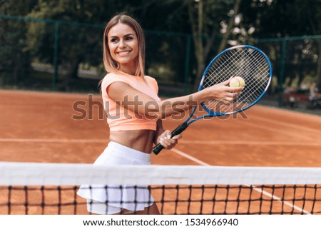 Smiling young girl hits a ball on the ball