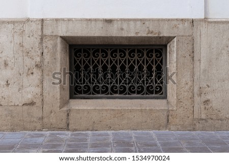 Vintage window with metal grill on stone wall. Valencia, Spain
