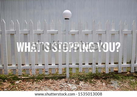 Motivational quotes- What’s stopping you?. White fence and street light with white background.