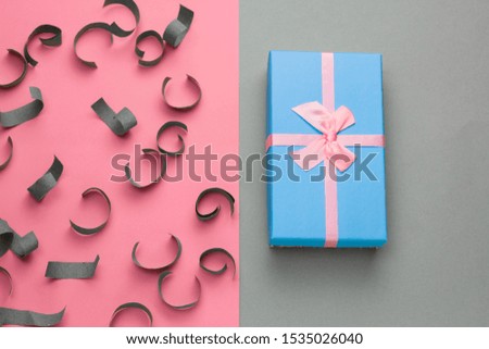 top view blue gift box with festive pink bow on a gray background with pastel pink frame 