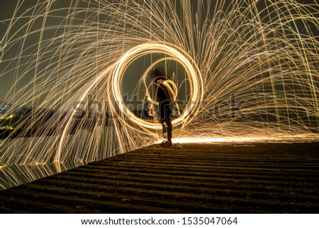 Young man doing steelwool photography in the middle of the night in Italy