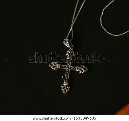 silver corss necklace on black background Royalty-Free Stock Photo #1535049605